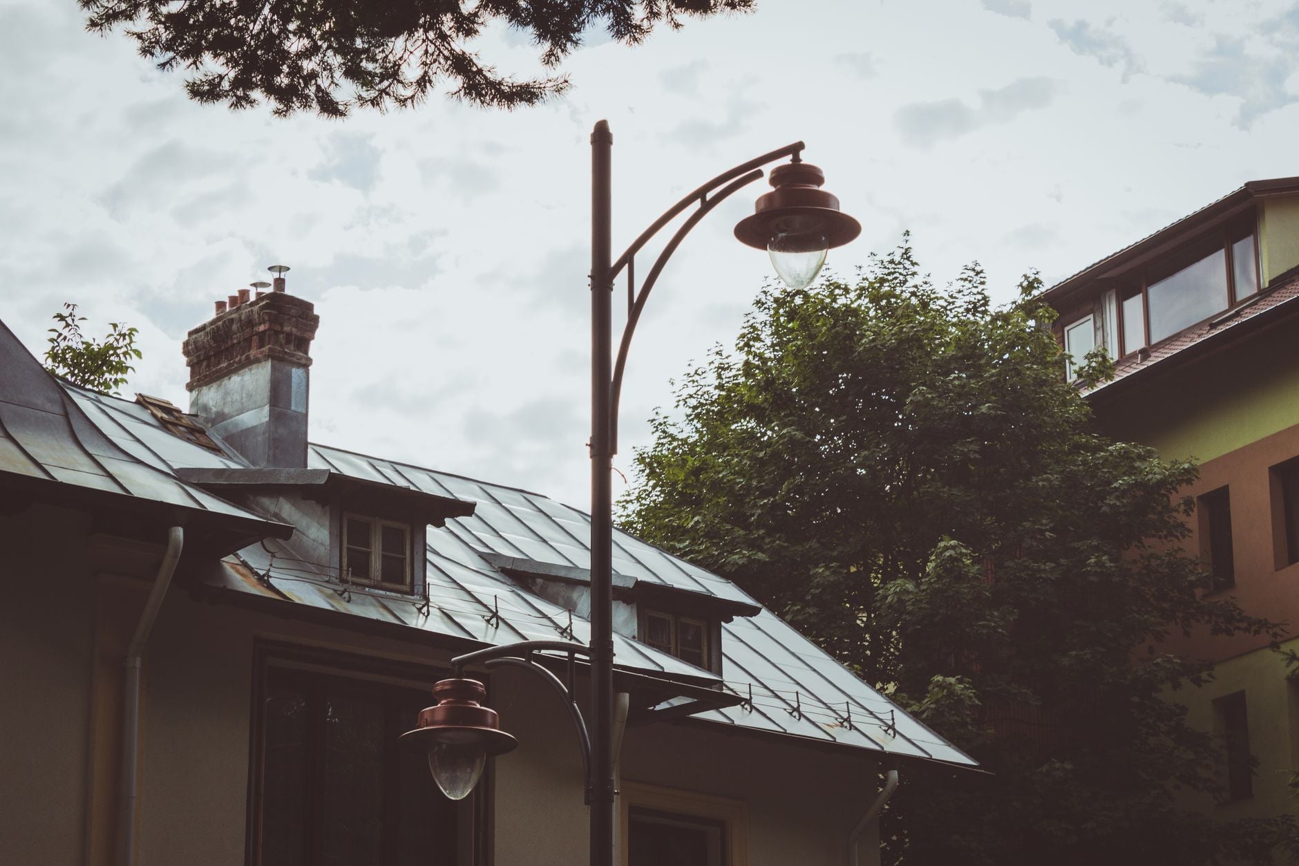 A cozy urban scene featuring a classic street lamp and traditional rooftops in Brașov, Romania.