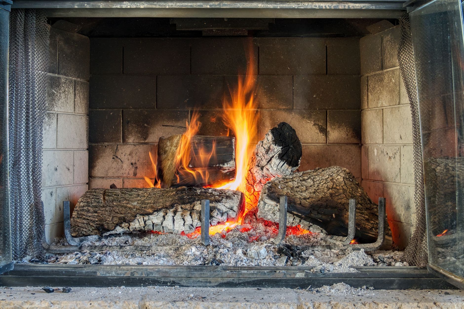 Warm and cozy fireplace with logs burning bright, providing warmth indoors.